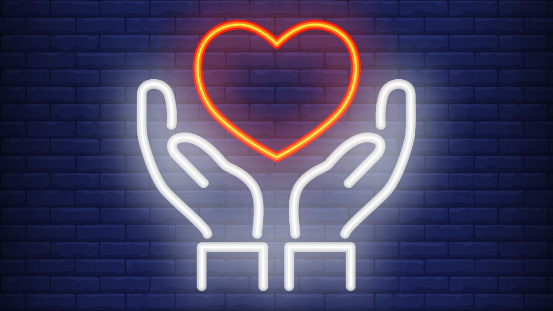 Hands holding heart neon sign